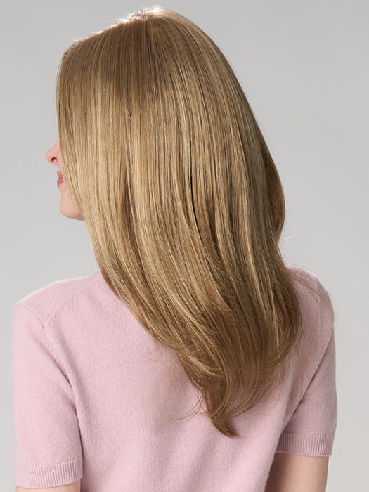 Woman with long, straight blonde hair wearing a pink sweater on a gray background