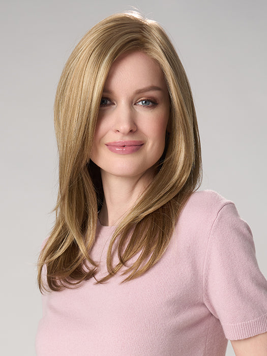 Woman with long blonde hair wearing a pink sweater on a gray background