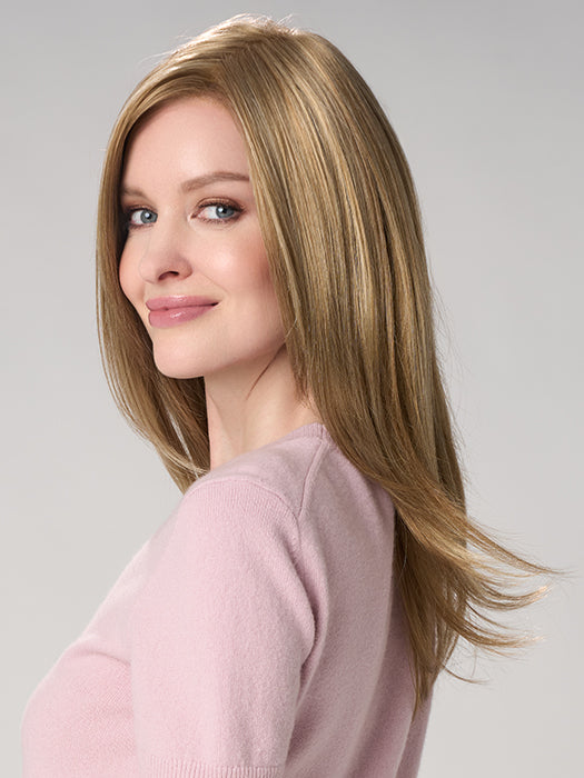 Woman with long, straight blonde hair wearing a pink sweater on a gray background
