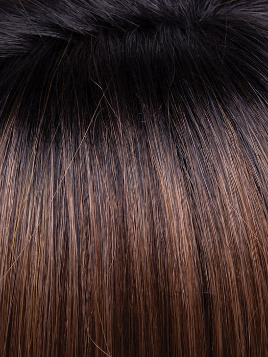 Close-up of dark brown hair with a fluffy black object above it