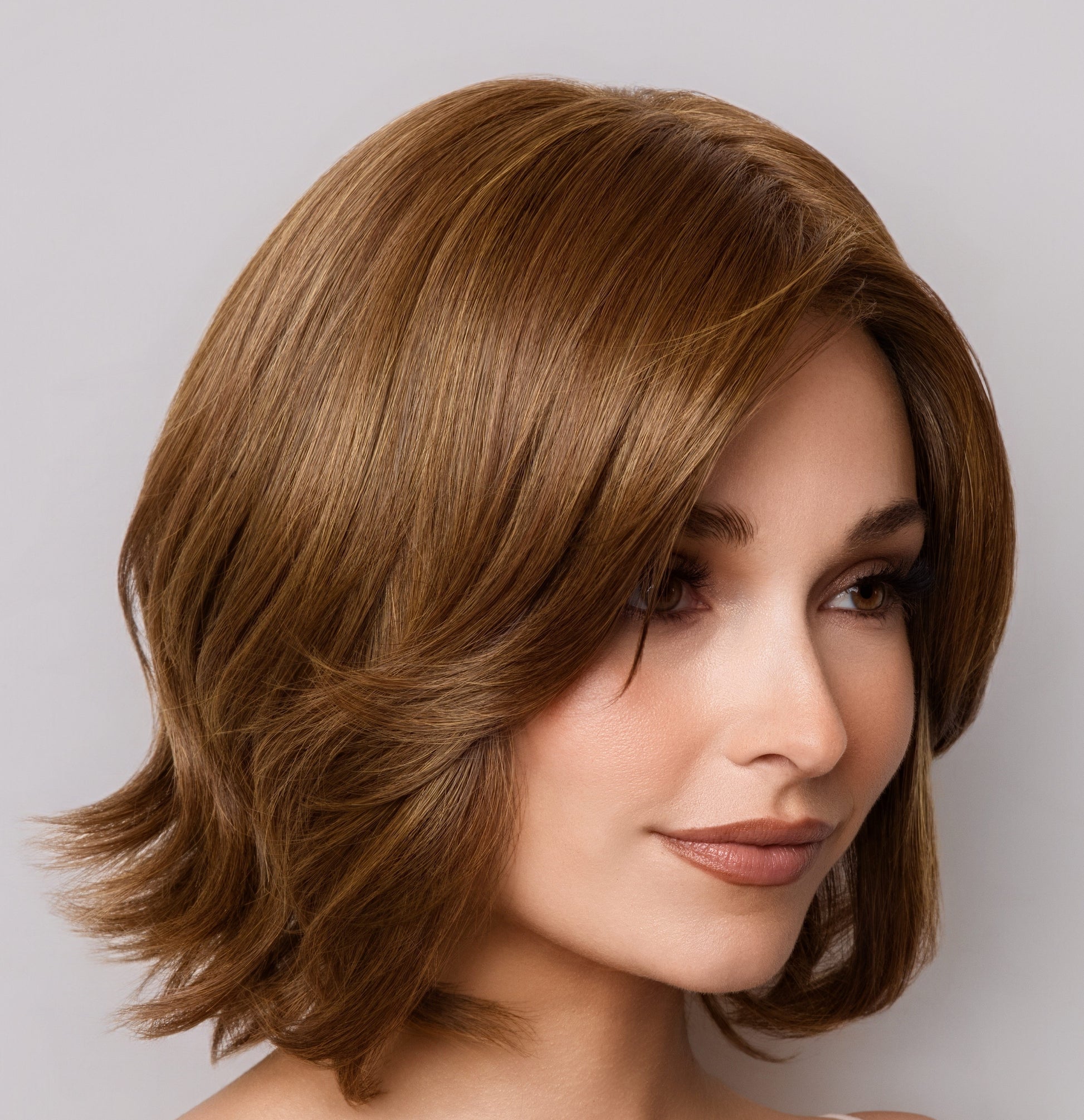 Woman with styled brown hair against a neutral background