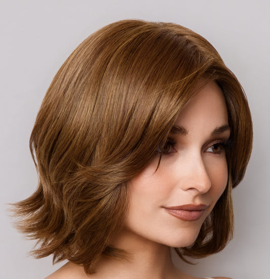 Woman with styled brown hair against a neutral background