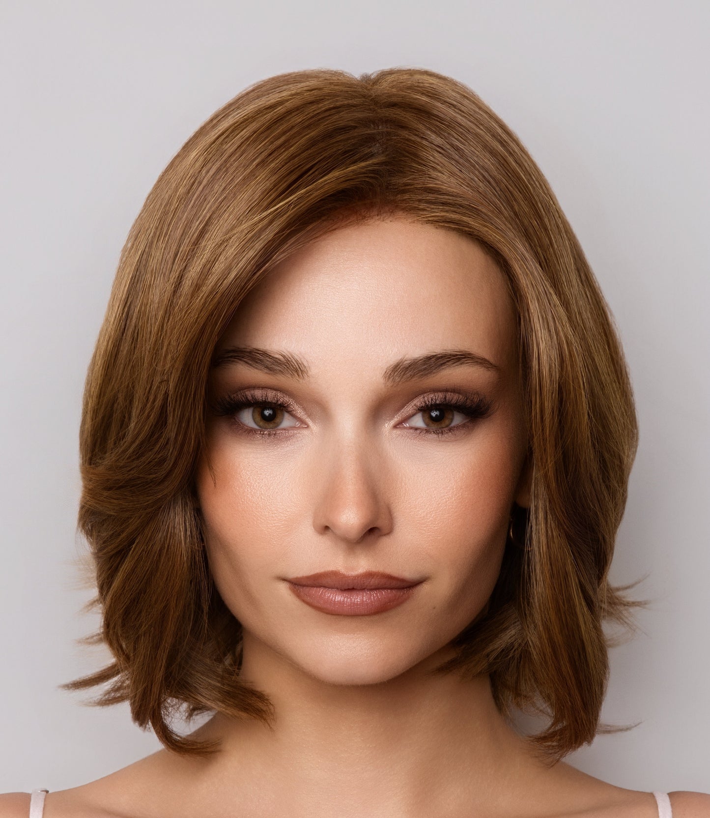 Woman with styled brown hair against a plain background