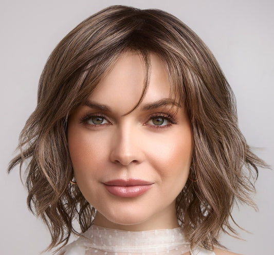 Woman with styled brown hair against a neutral background
