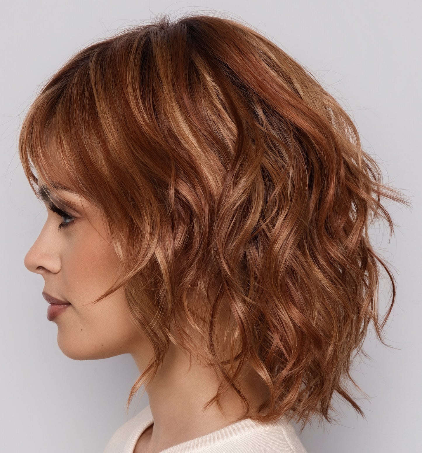 Woman with styled brown hair against a plain background