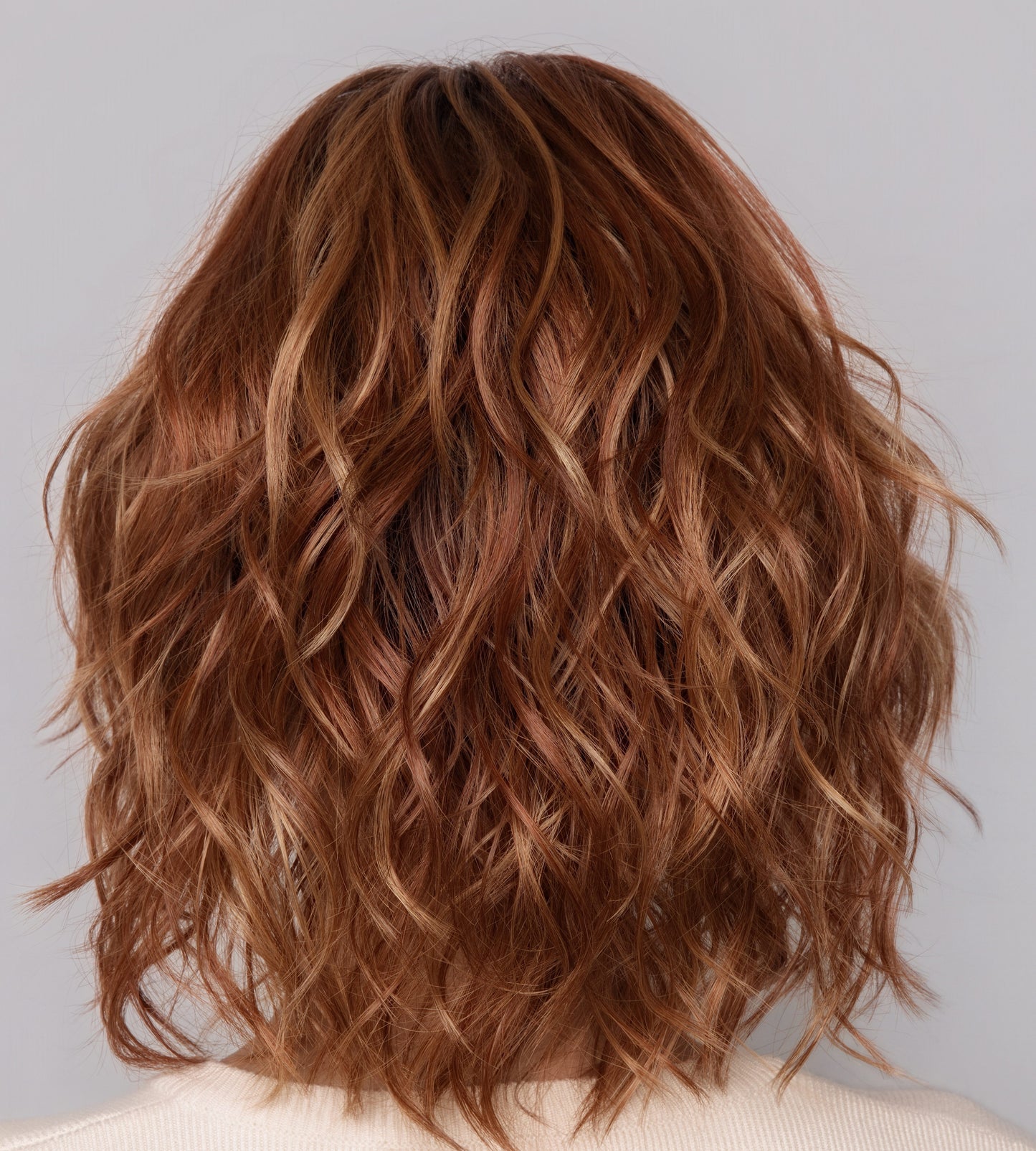 Brown wavy hair against a light gray background