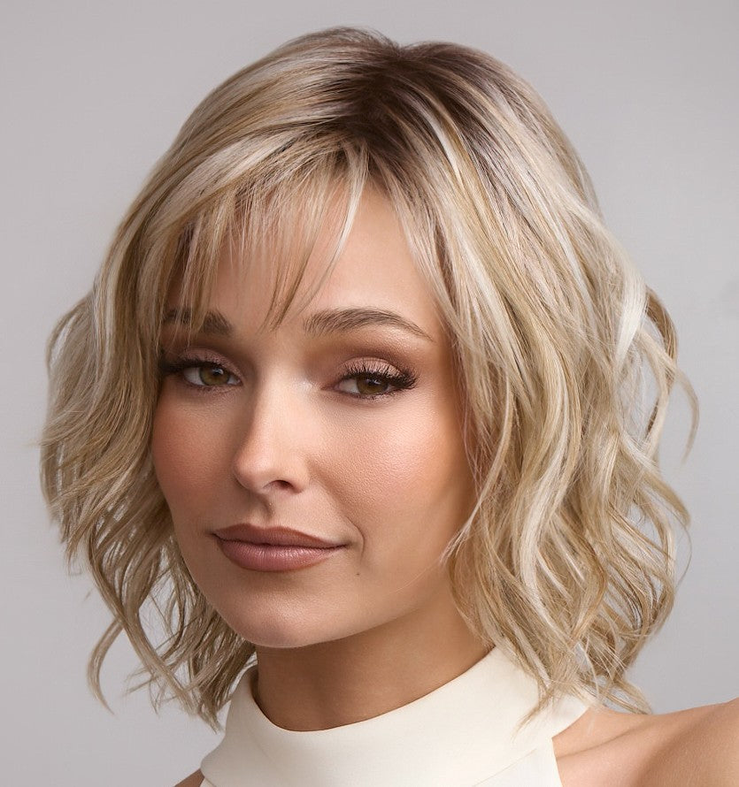Woman with styled blonde hair against a neutral background